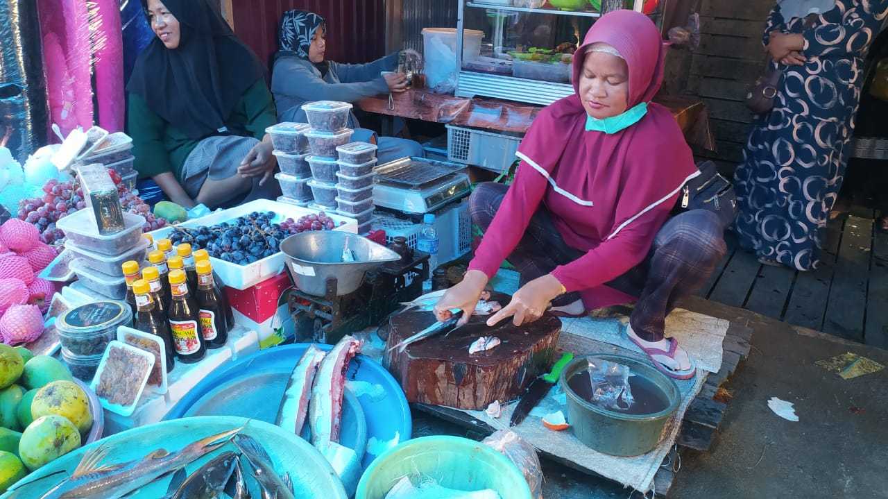 Noor Lia sibuk membersihkan ikan hasil tangkapan alam siap untuk dijual. | Foto: rdy
