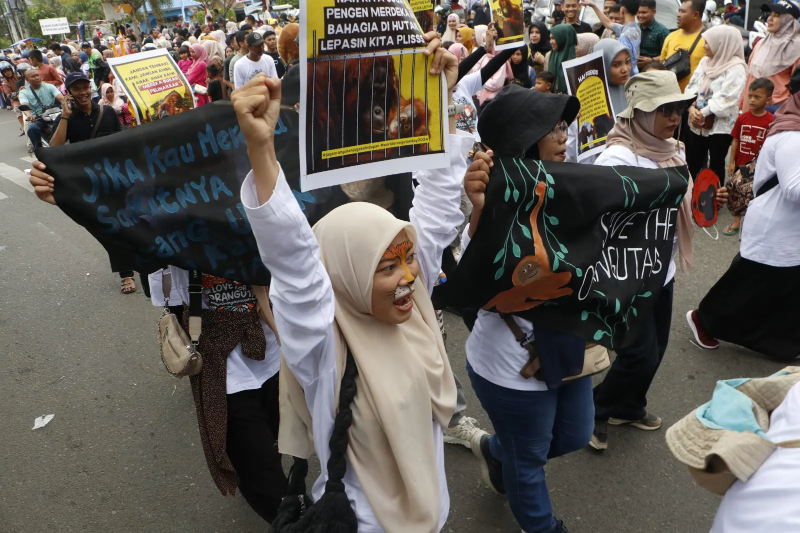 Seorang peserta parade mengepalkan tangan untuk menyerukan perlindungan satwa di Aceh. | Foto: Mardili/Garda Animalia